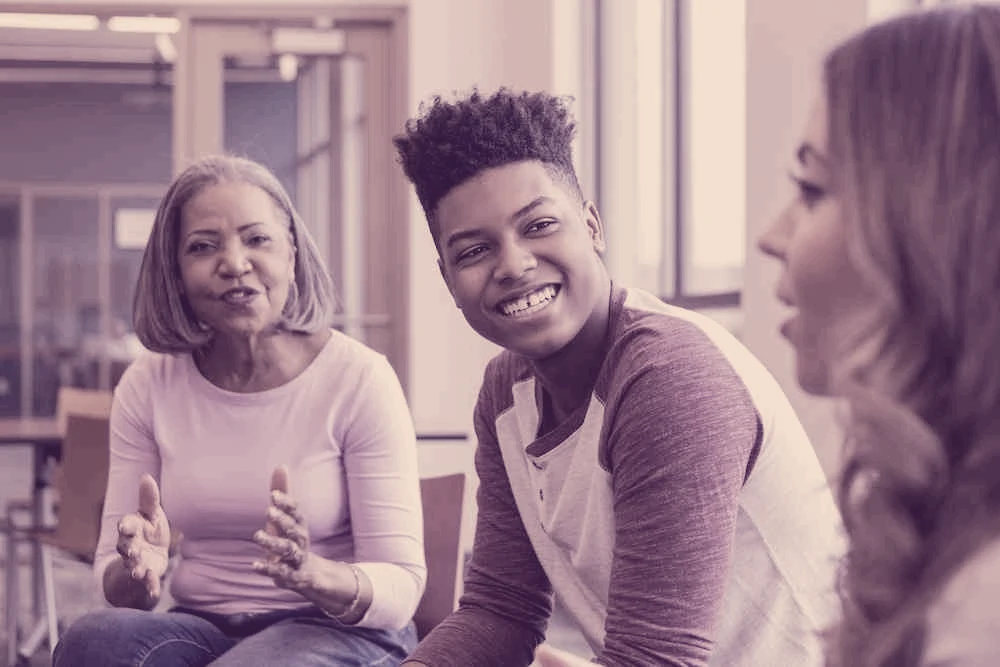 Illustrated conversation: a smiling young person listens between two adults.